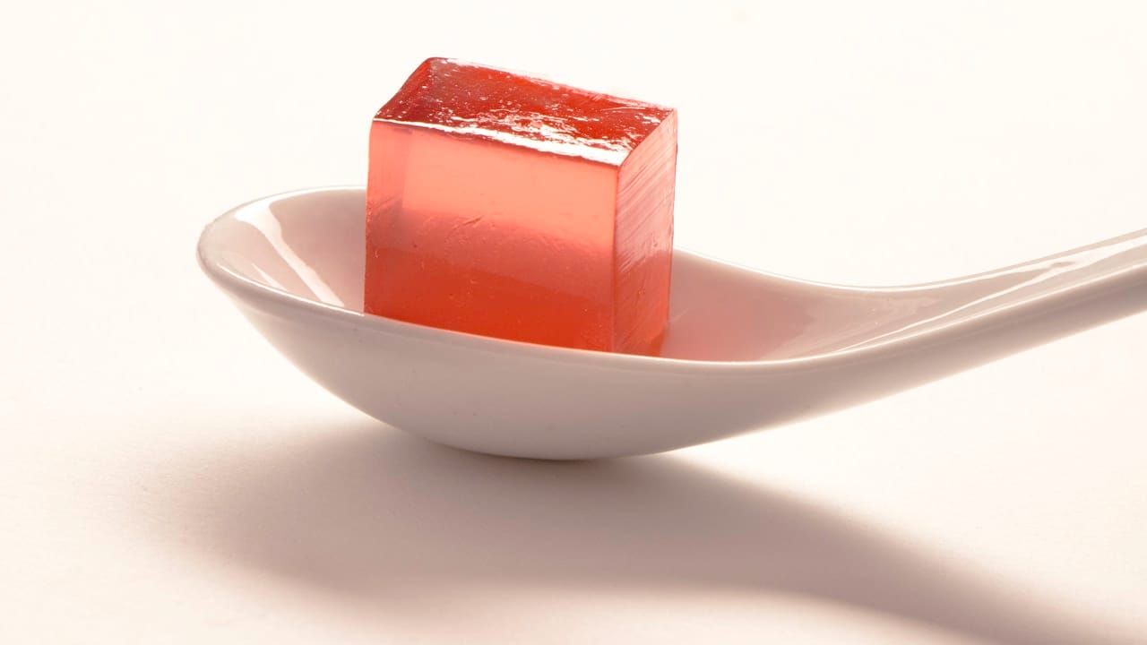 a spoon with a small cube of sugar on it