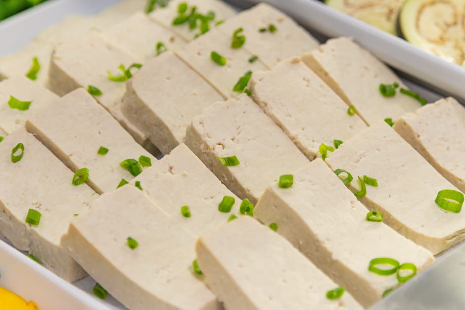 Close-up of tofu slices garnished with green onions, ideal for vegan meals.