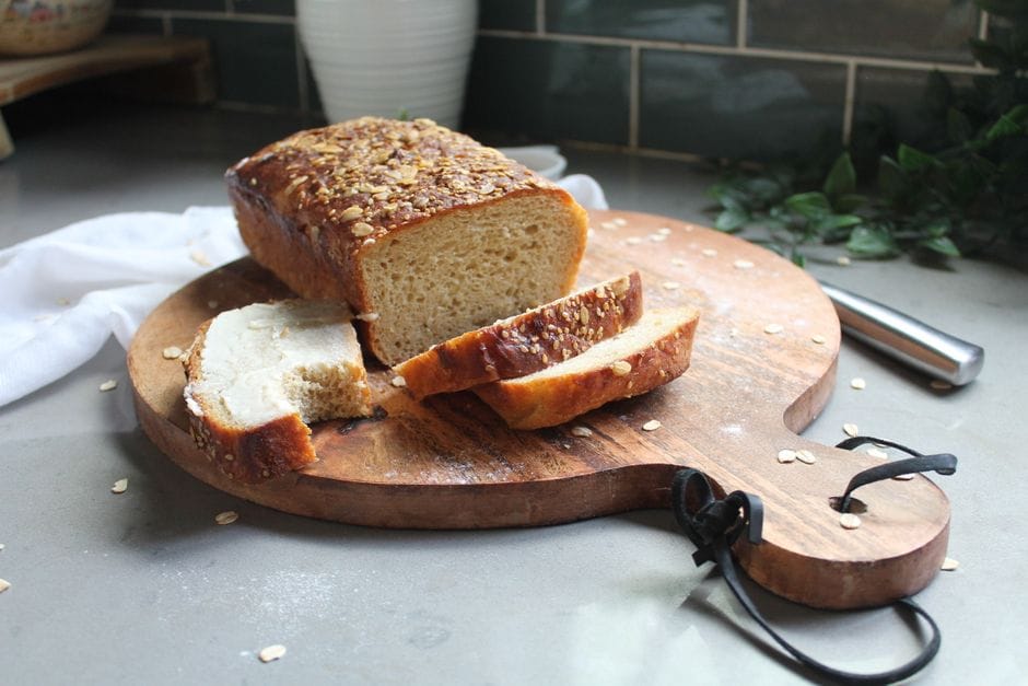Delicious freshly baked oat bread on a wooden board indoors, perfect for healthy nutrition.