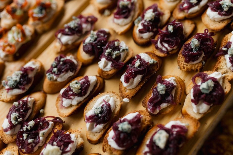 Delicious gourmet bruschetta topped with creamy cheese and caramelized onions.