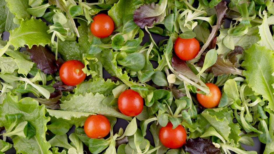 Top view of fresh mixed greens and cherry tomatoes, perfect for salads.