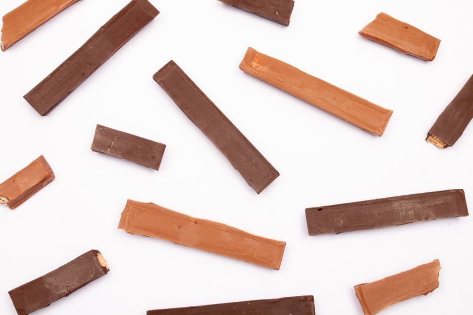 A flat lay of assorted chocolate bars with varying shades on a white background.