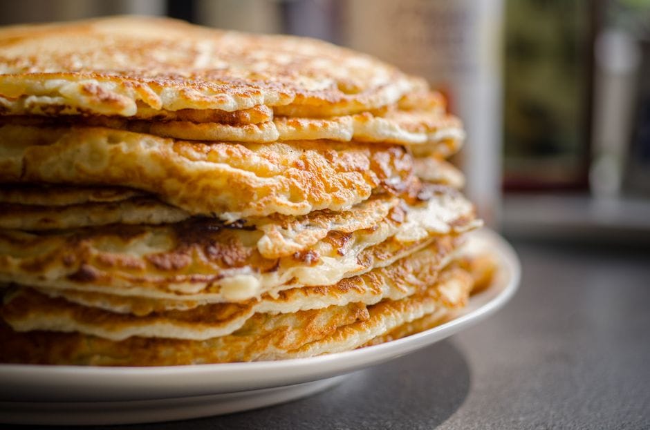 Close-up of delicious homemade pancakes stacked high on a plate, perfect for breakfast.