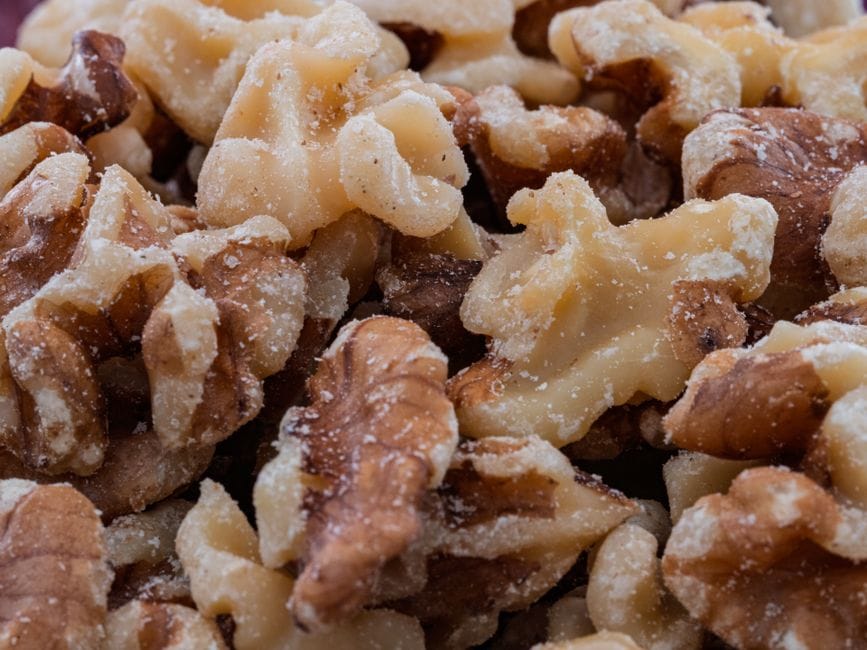 Detailed close-up shot of raw walnut halves, ideal for culinary and health-related themes.