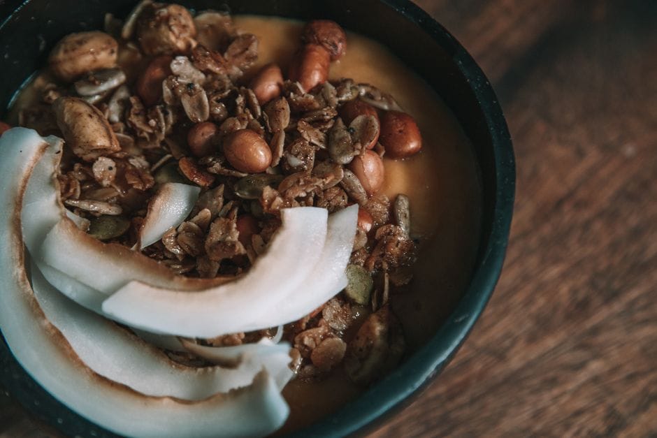 Delicious granola and coconut slices in a rustic breakfast bowl, perfect for a healthy start.