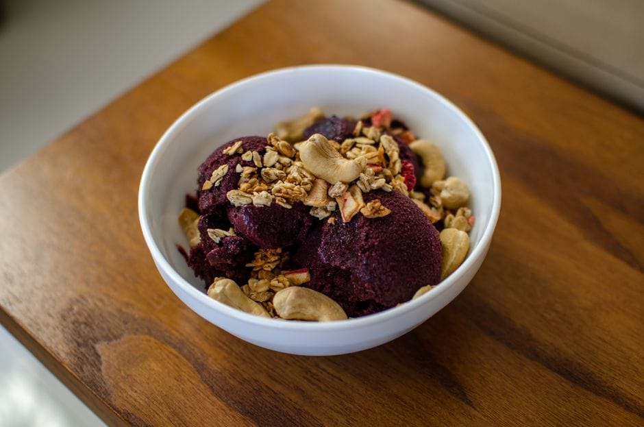 Delicious açaí bowl topped with granola and cashew nuts, perfect for a healthy dessert.
