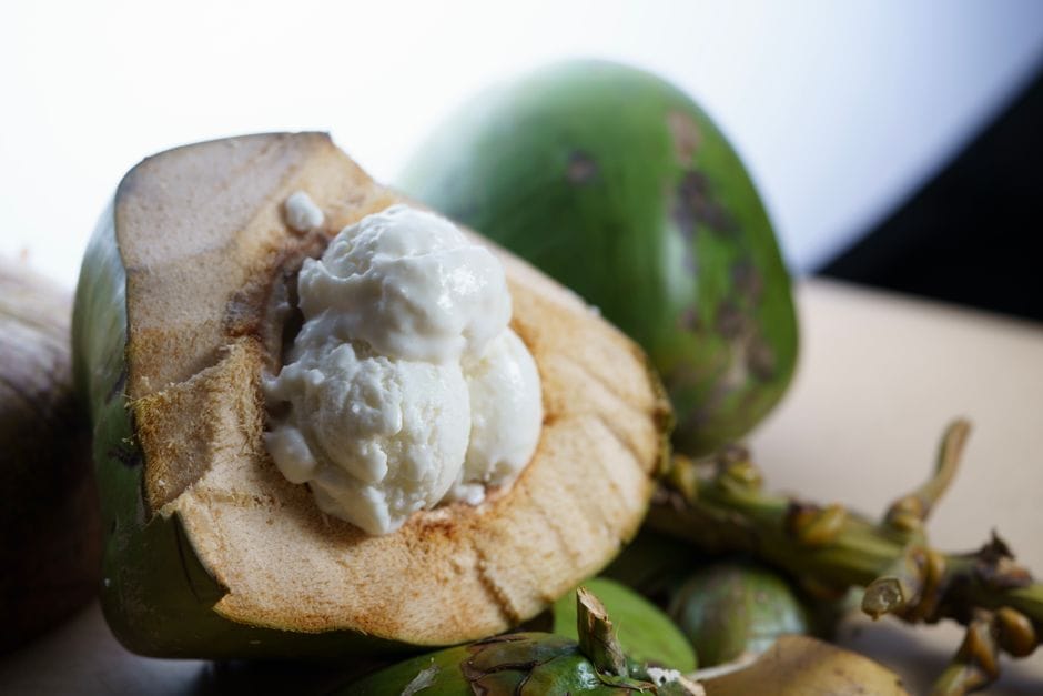 Close-up of ice cream served in a fresh coconut, offering tropical delight.