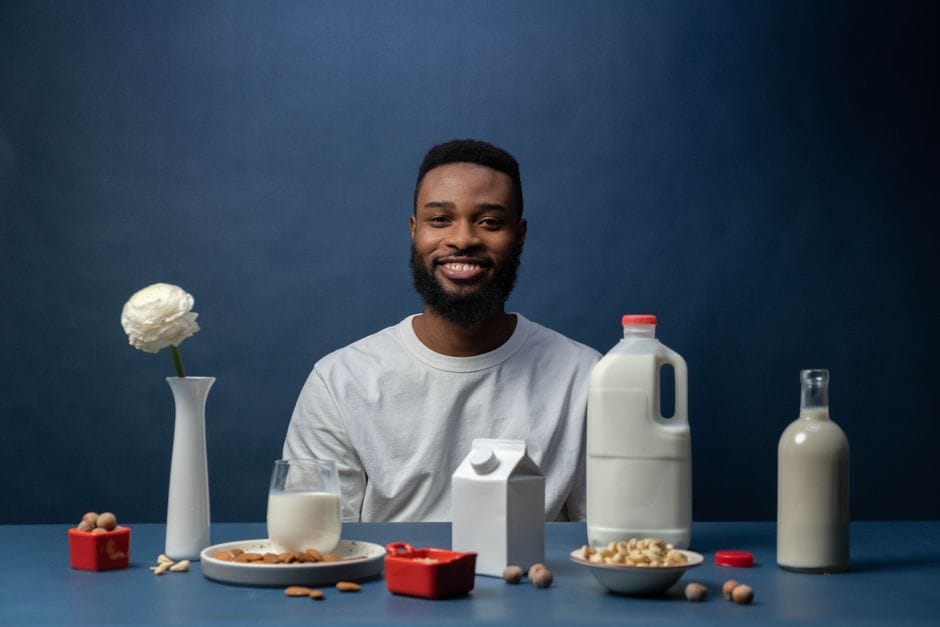 Smiling man enjoying a nutritious almond milk breakfast with cereals and nuts.