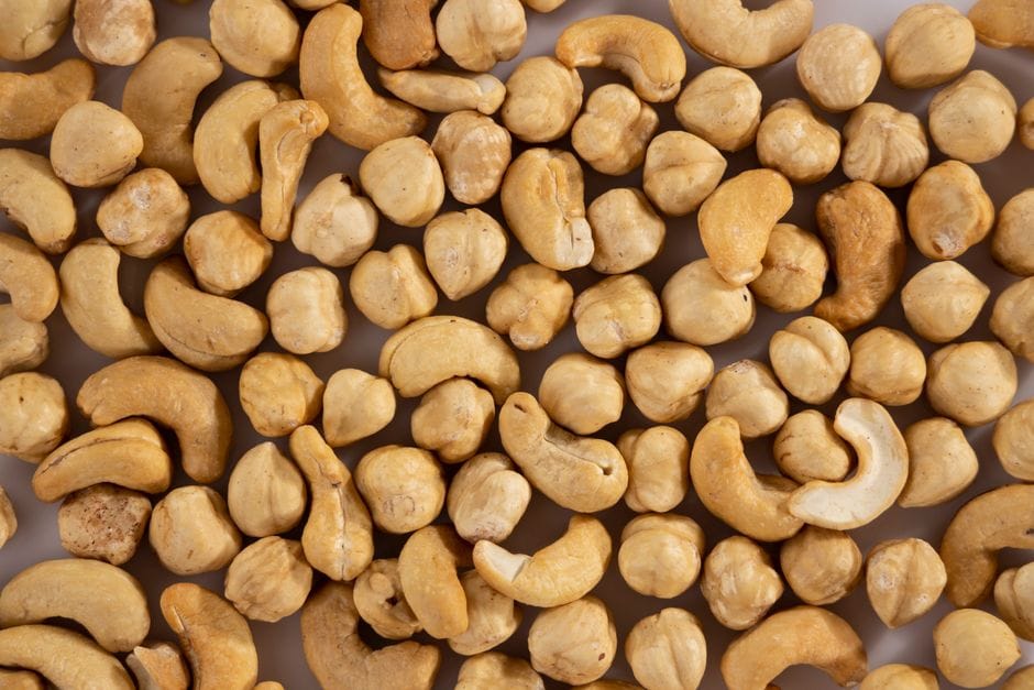 Close-up of assorted cashew and macadamia nuts, showcasing texture and variety.
