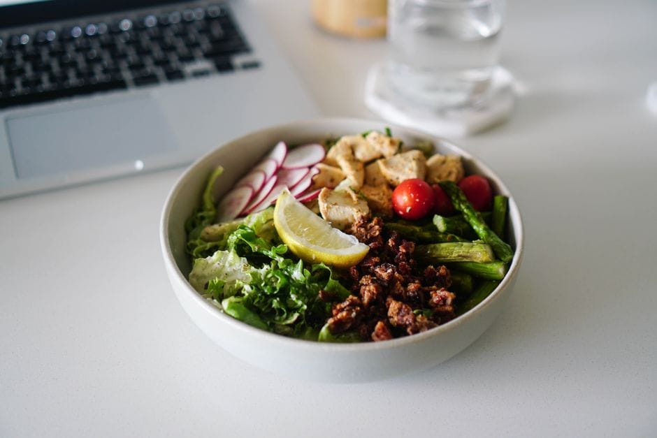 Delicious salad bowl with a variety of fresh vegetables, tofu, and a lemon slice, perfect for a nutritious meal.