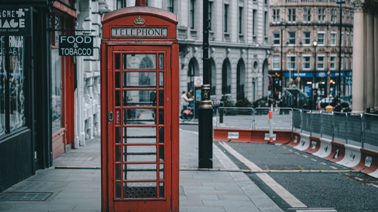 Classic London street scene featuring a red telephone booth, perfect for travel photography.